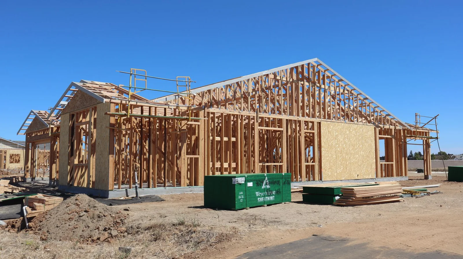 Maison individuelle neuve RE2020 en cours de construction, charpente bois visible